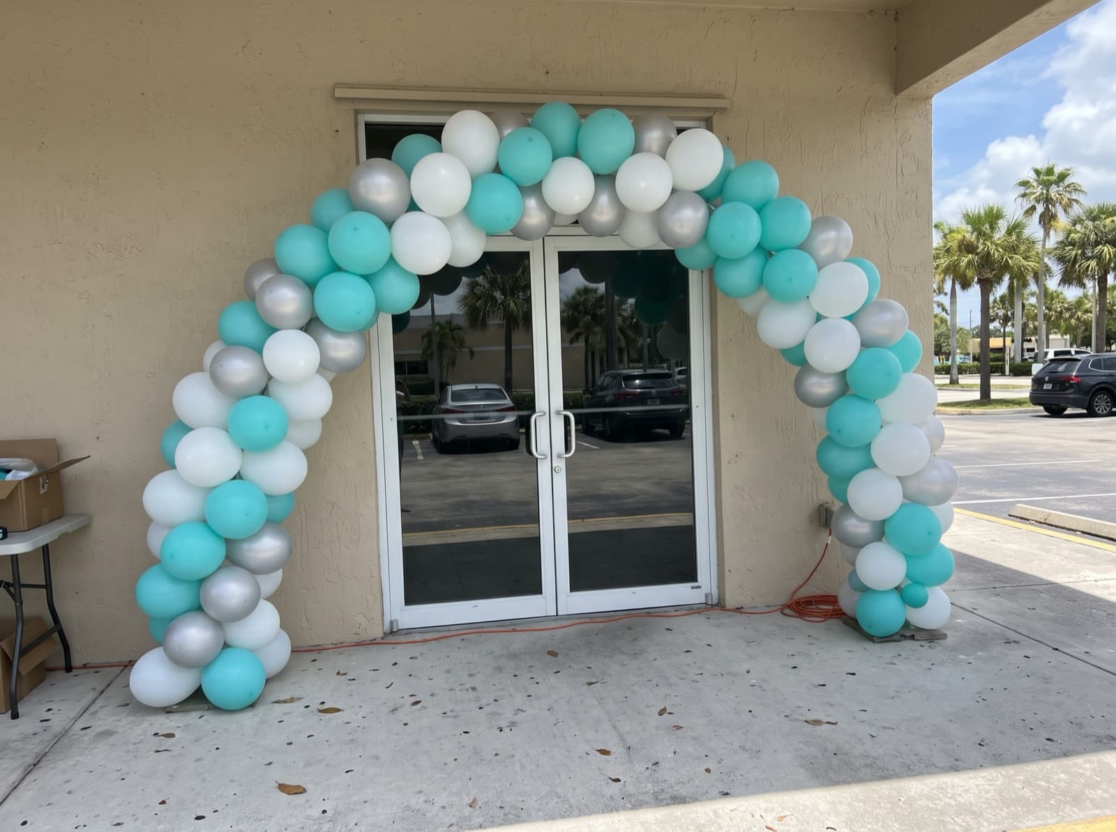 Large balloon arch over a storefront entrance