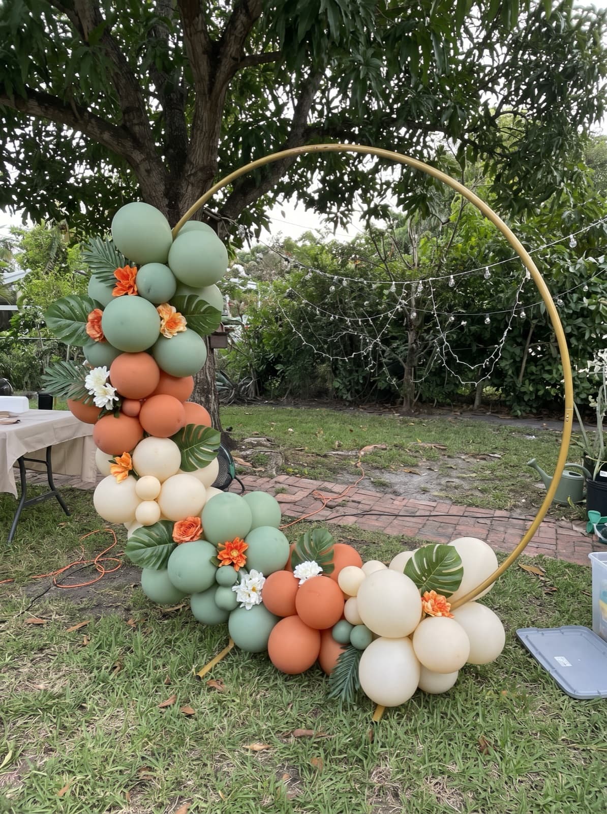 Balloon hoop backdrop with tropical florals on a lawn