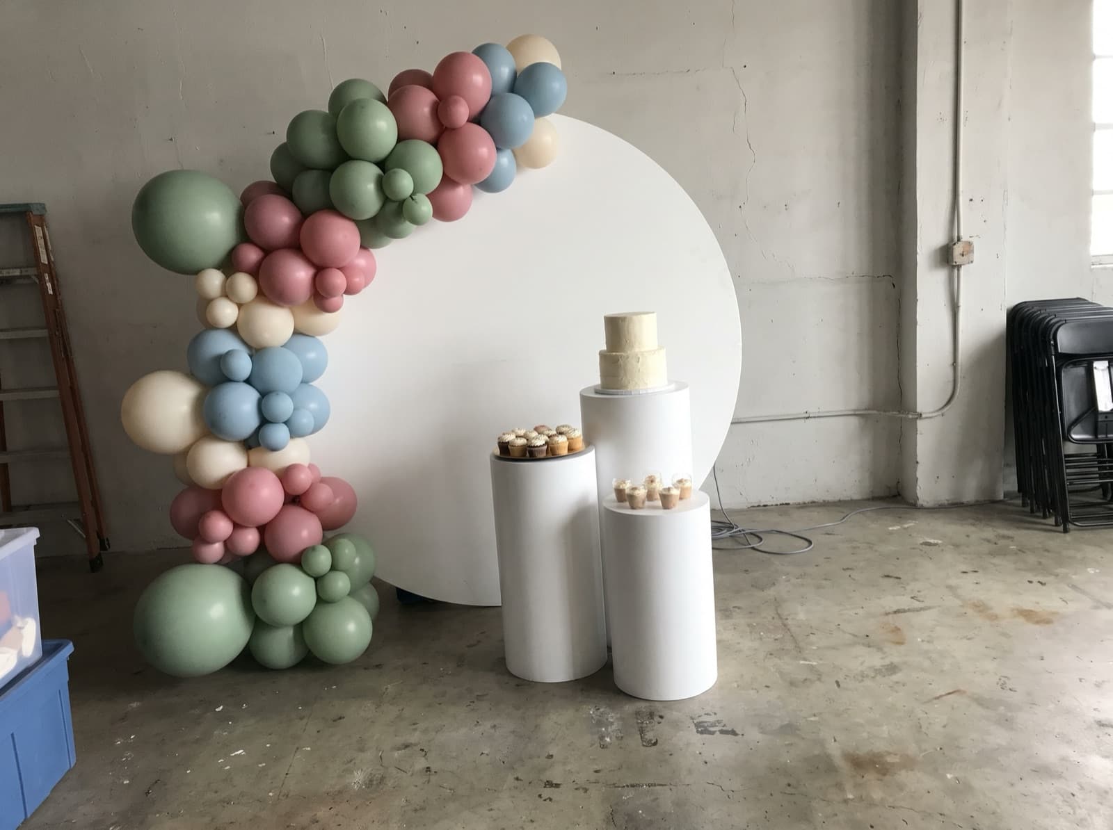 Balloon backdrop with pedestals and a cake table