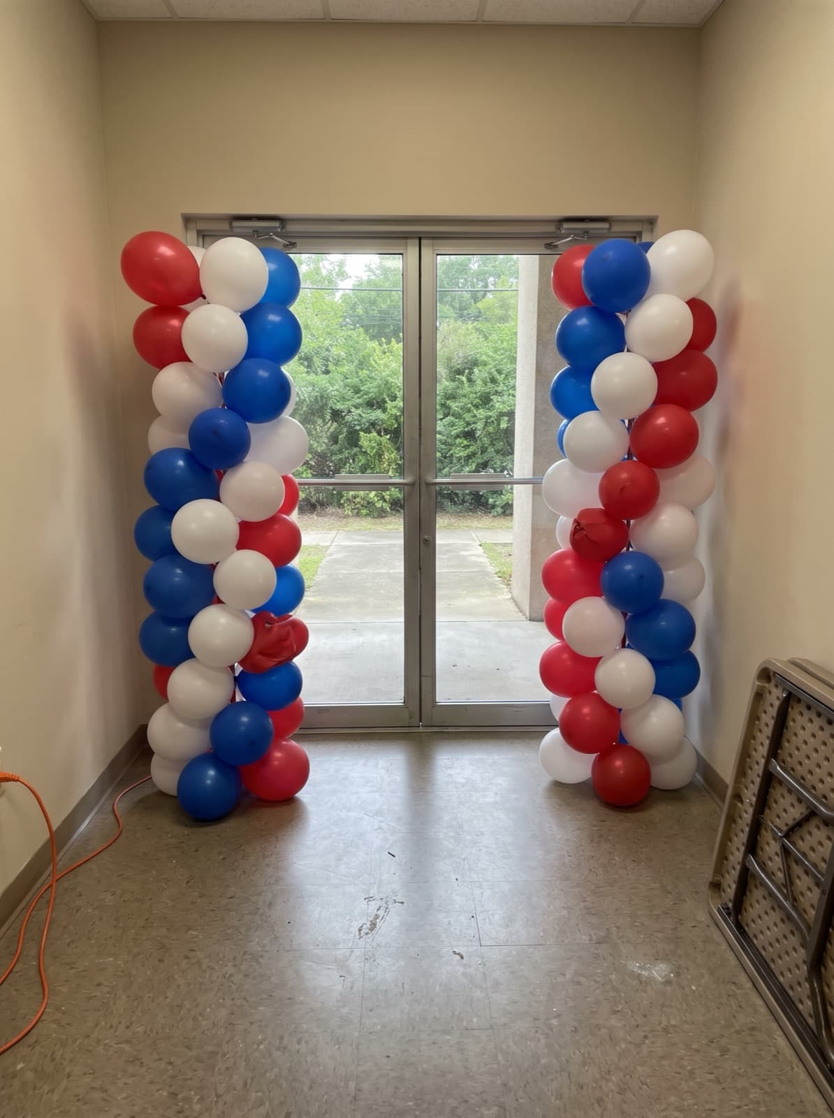 Red, white and blue spiral balloon columns at an office lobby