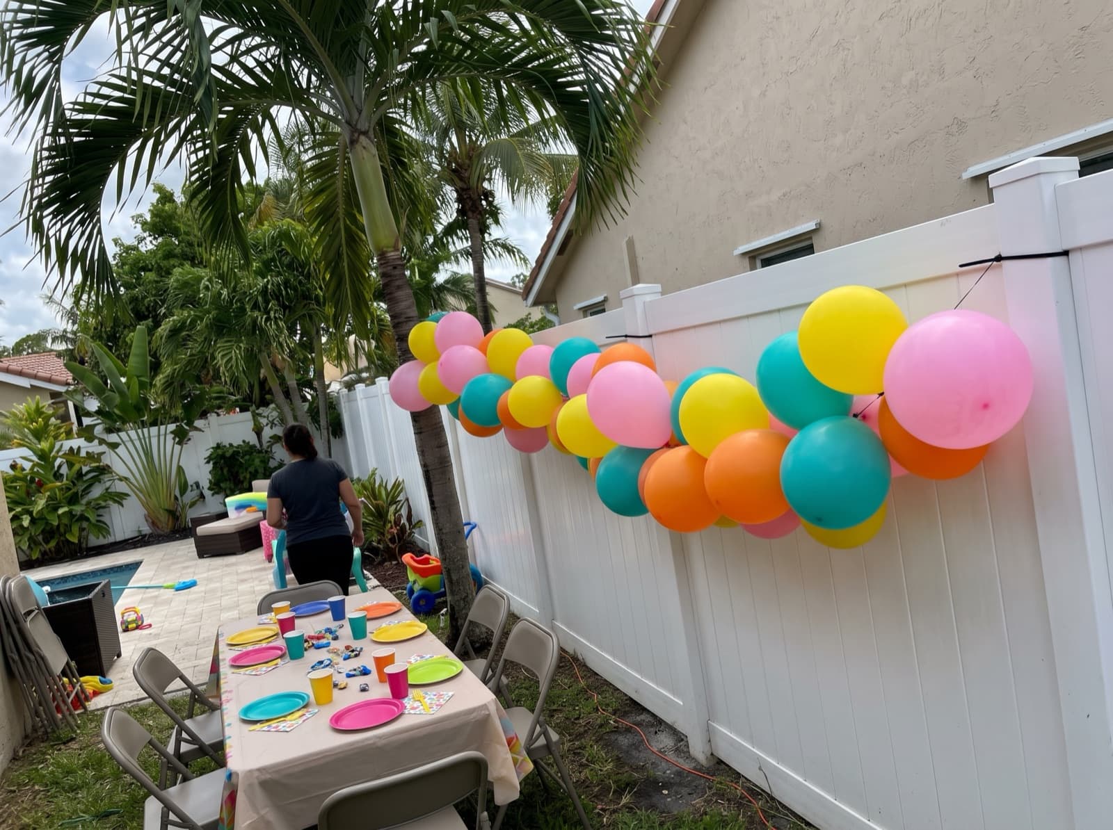 Balloon garland on a backyard fence at a kids' party
