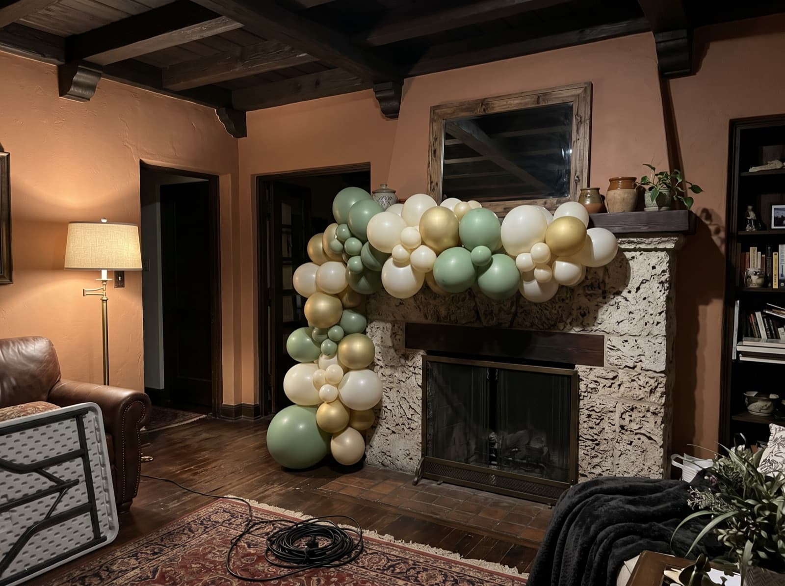 Organic balloon garland on a coral-stone fireplace mantel