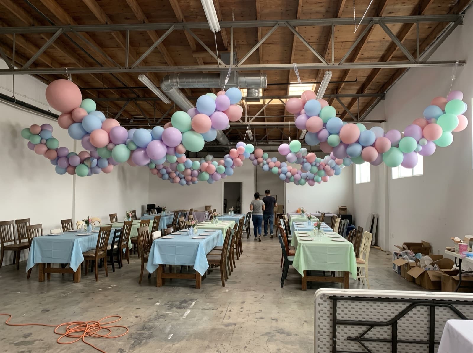 Hanging balloon garland canopy over dining tables