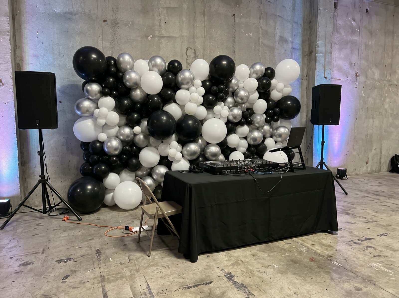 Balloon wall behind a DJ booth in a warehouse venue