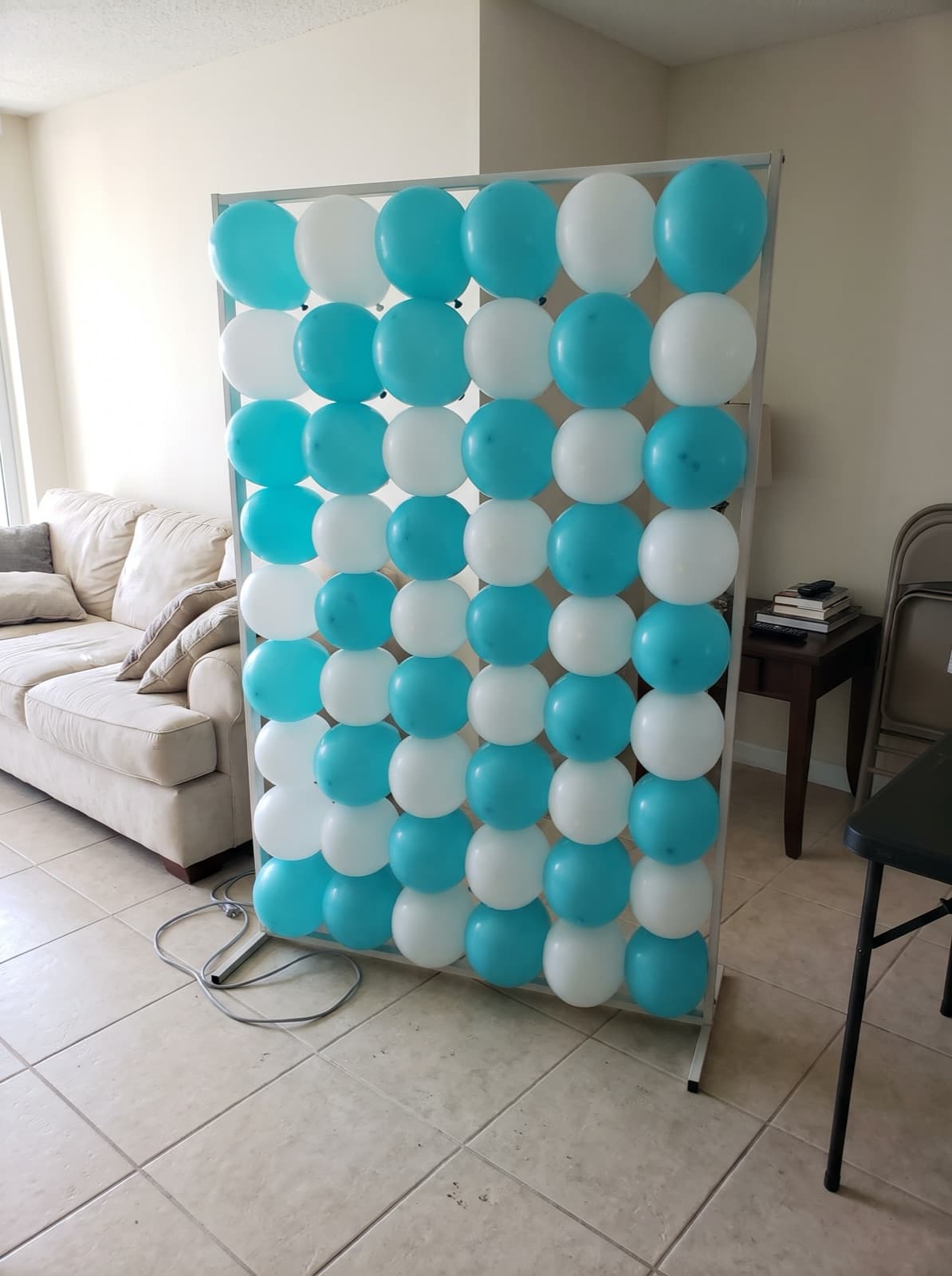 Grid balloon wall in turquoise and white on a freestanding frame